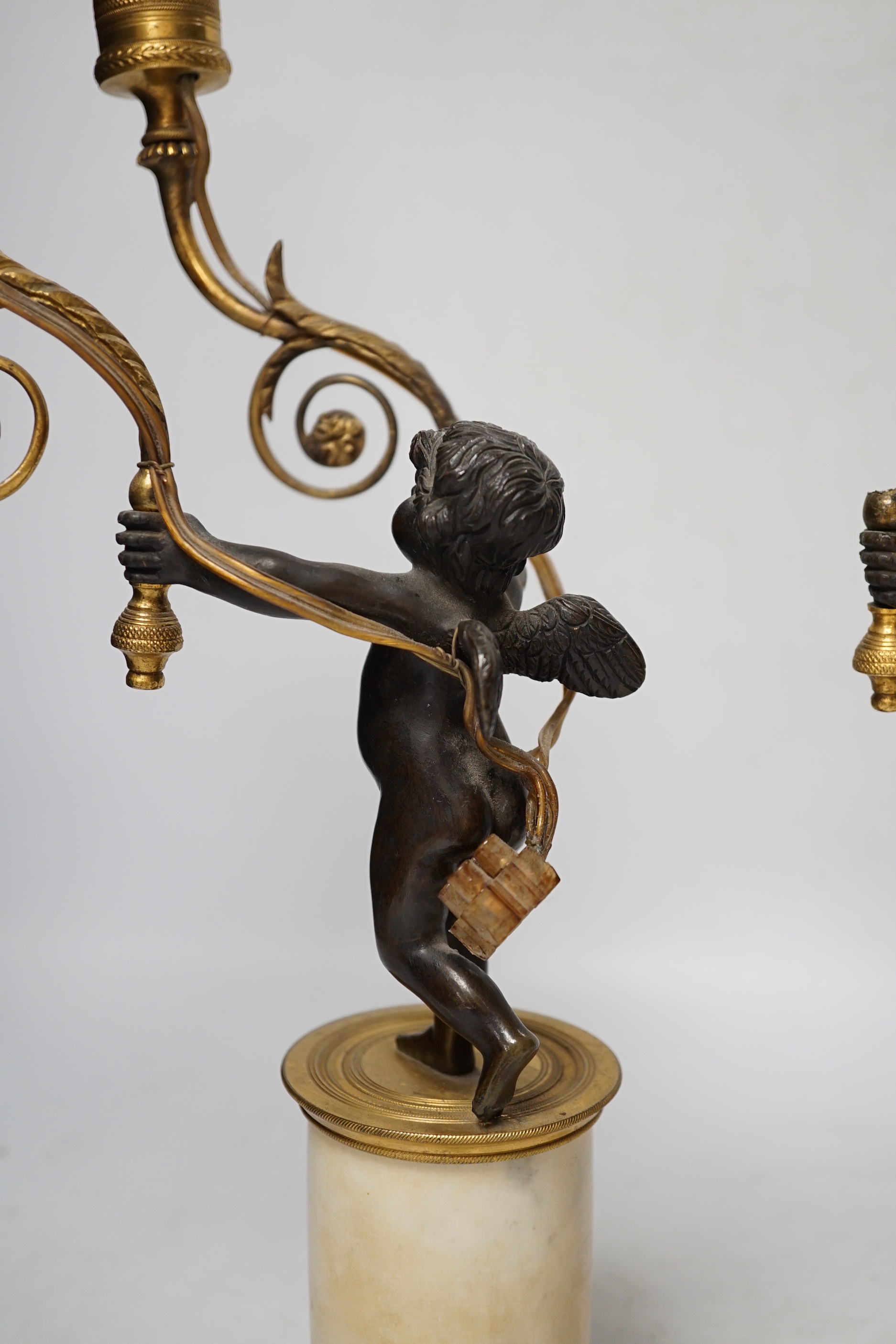 A pair of Louis XVI style bronze, ormolu and alabaster cherub lamps, 42cm high (one a.f.)